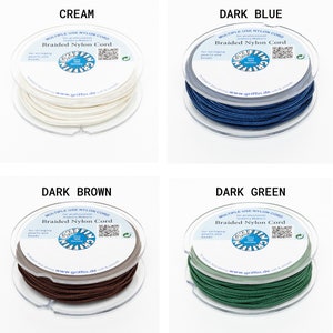 Puede incluir: Cuatro carretes de cord&oacute;n de nailon trenzado Griffin en crema, azul oscuro, marr&oacute;n oscuro y verde oscuro. Cada carrete est&aacute; etiquetado con el texto "Multiple Use Nylon Cord" y "Braided Nylon Cord" para ensartar perlas y abalorios.