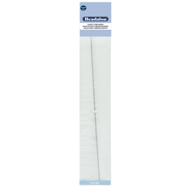 May include: A silver elastic cord needle, 25 inches long, packaged on a white card with blue text that reads "Beadalon Elastic Cord Needle Aiguille pour cordon &eacute;lastique Aguja para cord&oacute;n el&aacute;stico 1 pc/pz".