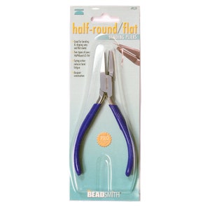 Puede incluir: Alicates de doblado medio redondos/planos con mangos azules. Los alicates están empaquetados en una tarjeta blanca con el texto "alicates de doblado medio redondos/planos" y "CALIDAD PRO" impreso en ella. El nombre de la marca "BEADSMITH" está impreso en la parte inferior de la tarjeta.