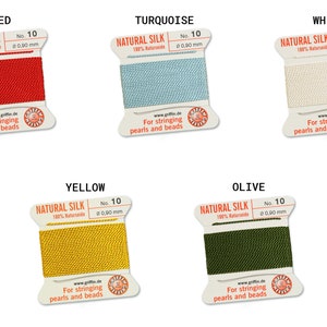 May include: Five spools of natural silk thread for stringing pearls and beads. The spools are labeled with the colors red, turquoise, white, yellow, and olive.