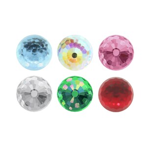 Puede incluir: Seis cuentas redondas de vidrio facetado e iridiscente en varios colores: azul claro, blanco iridiscente, rosa, verde y rojo.