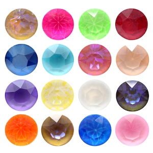 Pode incluir: Uma coleção de dezasseis pedras preciosas redondas e facetadas em várias cores. As pedras preciosas incluem tons de amarelo, rosa, verde, vermelho, azul, roxo e transparente. Cada gema tem uma superfície multifacetada, refletindo a luz.