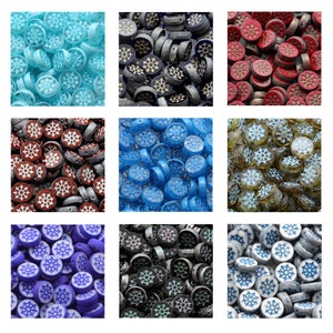 Könnte beinhalten: Sortiment an Glasfliesenperlen mit Schneeflockenmuster in verschiedenen Farben, darunter Blau, Rot, Schwarz, Weiß und Gold.