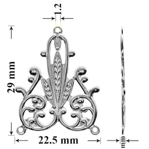 May include: Silver-toned metal pendant with a decorative design featuring a stylized floral motif. The pendant measures 29 mm in height, 22.5 mm in width, and 1.2 mm in thickness.
