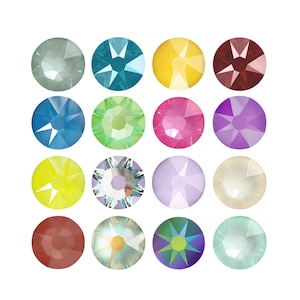 Peut inclure: Une collection de seize cristaux circulaires à facettes disposés en une grille de quatre par quatre. Les pierres présentent une variété de couleurs, dont des tons de bleu, vert, jaune, rouge, rose, violet, blanc et des finitions irisées.