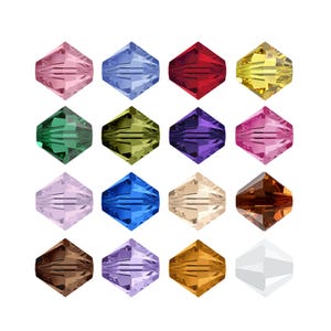 May include: A collection of sixteen faceted bicone beads arranged in a four-by-four grid. Each bead features a distinct colour, including shades of pink, blue, red, yellow, green, olive, purple, lavender, brown, tan, and a clear white bead.