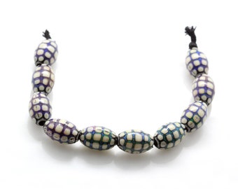 May include: A strand of oval-shaped beads with a checkered pattern in shades of white, blue, and purple. The beads are strung on a black cord.