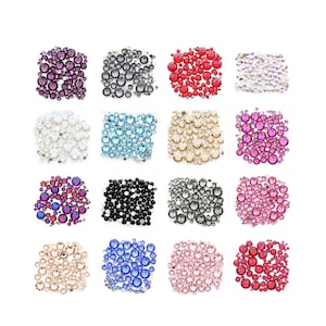 Puede incluir: Surtido de 12 colores diferentes de diamantes de imitación, cada color se muestra en una pila separada. Los colores incluyen: negro, blanco, rojo, rosa, morado, azul, azul claro, azul oscuro, dorado, plateado, transparente e iridiscente.
