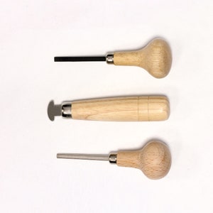 Può includere: Tre strumenti con manico in legno e punte in metallo. Gli strumenti sono utilizzati per modellare e levigare il metallo.