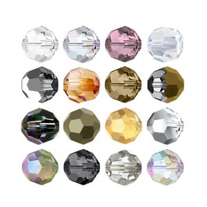 Könnte beinhalten: Eine Sammlung von sechzehn facettierten Kristallperlen, die in einem Vier-mal-vier-Raster angeordnet sind. Die Perlen weisen verschiedene Farben auf, darunter klar, rosa, bernsteinfarben, gold, schwarz, silber und irisierende Töne.