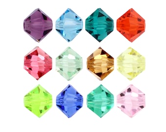 Op de afbeelding: Twaalf gefacetteerde glazen kralen in verschillende kleuren, waaronder paars, blauw, groen, rood, roze, geel en oranje. De kralen zijn gerangschikt in een rasterpatroon op een witte achtergrond.