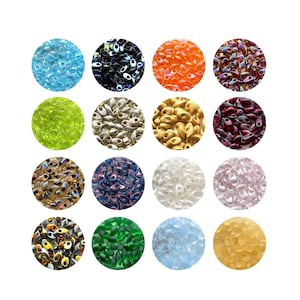 May include: A selection of oval seed beads in a variety of colours, such as blue, orange, green, and gold. The beads are arranged in circular patterns, suitable for jewellery making and crafts.