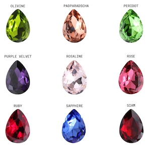 May include: Nine teardrop-shaped gemstones in various colors, including green, brown, red, blue, and purple. The gemstones are labeled with their names: Olivine, Padparadscha, Peridot, Purple Velvet, Rosaline, Rose, Ruby, Sapphire, and Siam.