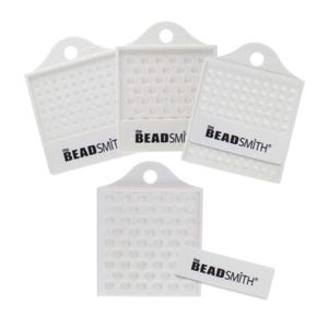 May include: Four white plastic beading trays with a hole at the top. Each tray has a grid of small circles and the text "the BEADSMITH" printed on the bottom.