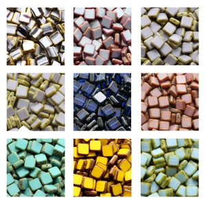 Könnte beinhalten: Sortiment an quadratischen Glasperlen in verschiedenen Farben, darunter Gelb, Blau, Grün, Rosa und Weiß. Die Perlen haben eine glänzende Oberfläche und sind perfekt für die Schmuckherstellung oder zum Basteln.