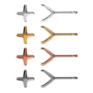 May include: Four earring settings in different metal finishes: silver, gold, rose gold, and black. Each setting features a cross-shaped base and a prong setting.