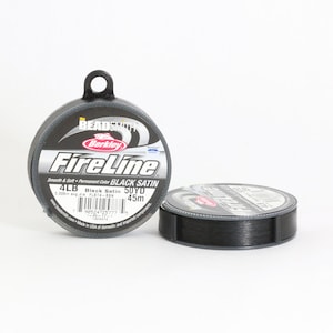 Puede incluir: Un carrete de l&iacute;nea de pesca FireLine negra de Berkley. El carrete est&aacute; etiquetado como "Black Satin" y tiene una resistencia de 4 lb, 50 yardas (45 metros).