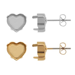 May include: Two pairs of heart-shaped earring settings, one pair in silver and one pair in gold. Each setting has a smooth, rounded edge and a flat base for attaching a stone or other embellishment.