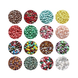 May include: A collection of colorful, double-holed seed beads in various colors, arranged in circular patterns. The beads are in shades of brown, red, teal, yellow, green, pink, and more. These beads are ideal for jewelry making and crafting projects.
