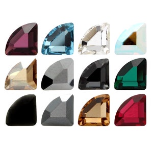 May include: Assortment of twelve corner shaped rhinestones in various colours, including clear, black, red, green, blue, and gold.