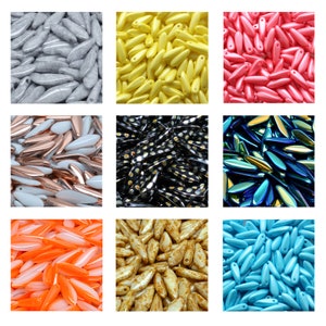 Peut inclure: Assortiment de perles de verre colorées de différentes formes et tailles. Les perles sont disposées en grille, chaque carré contenant une couleur différente. Les couleurs incluent le gris, le jaune, le rose, le blanc, le noir, le bleu, l'orange et le brun.