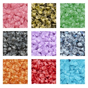 Könnte beinhalten: Sortiment an bunten Glasperlen in verschiedenen Formen und Größen. Die Perlen sind in einem Raster angeordnet, wobei jede Farbe ihr eigenes Quadrat einnimmt. Die Farben umfassen Pink, Gold, Grün, Grau, Lila, Silber, Orange, Rot und Blau.