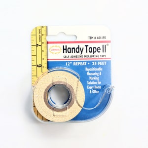 Puede incluir: Un paquete azul y amarillo de cinta métrica autoadhesiva Handy Tape II. La cinta mide 12 pulgadas de largo y se repite cada 2,5 pies. El paquete dice que es una solución de medición y marcado reposicionable para cada hogar y oficina.