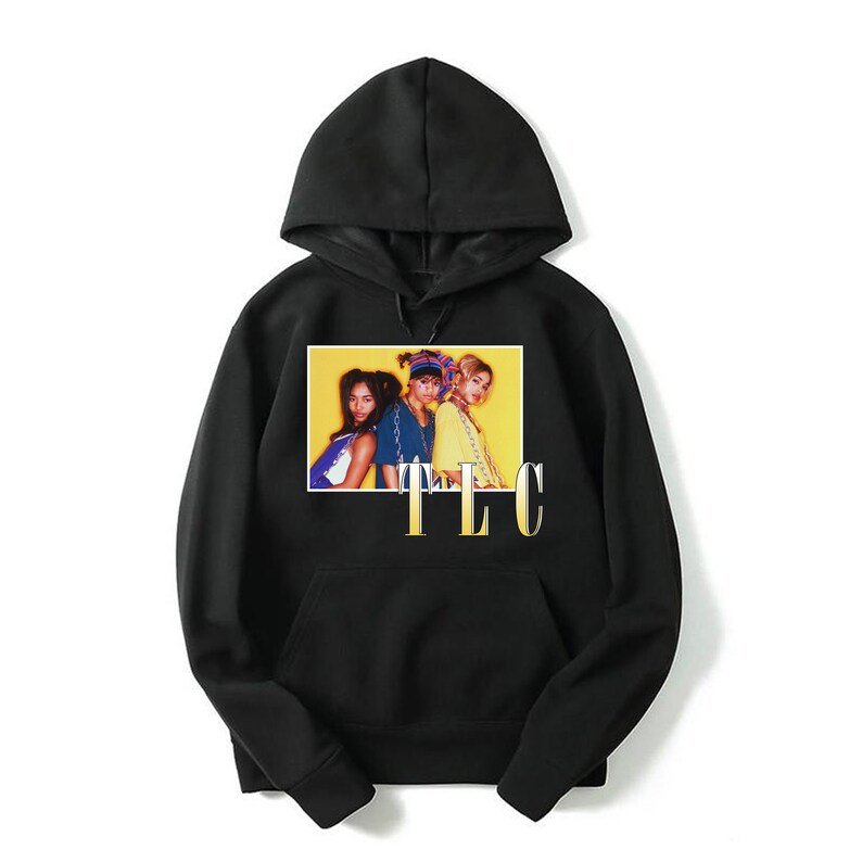 May include: Black hooded sweatshirt with a graphic print of the R&B group TLC. The image is on a yellow background with the group's name in gold letters below the image.