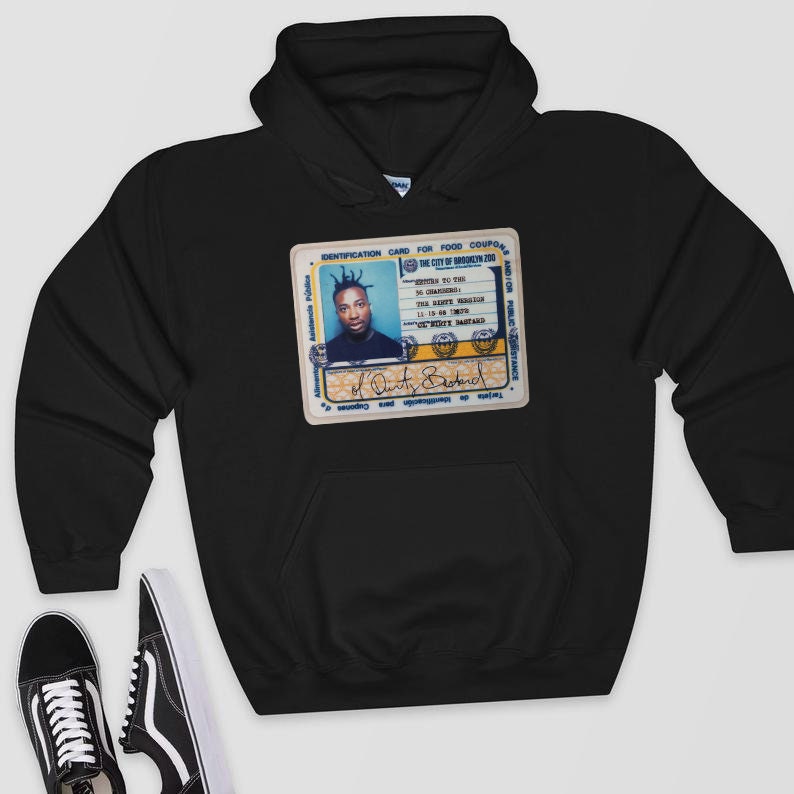 May include: Black hooded sweatshirt featuring a graphic of an ID card with a photo of a person and the text "The City of Brooklyn Zoo." The ID card has blue and yellow accents. The sweatshirt has a front pocket and a hood.