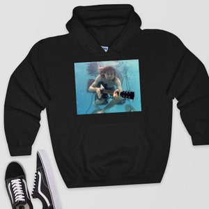 May include: Black hooded sweatshirt with a graphic print of a person playing a guitar underwater. The person is wearing a white shirt and has long, dark hair.