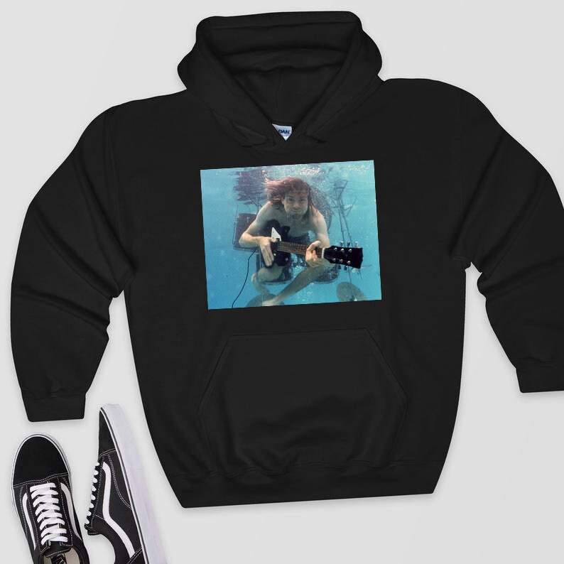 May include: Black hooded sweatshirt with a graphic print of a person playing a guitar underwater. The person is wearing a white shirt and has long, dark hair.