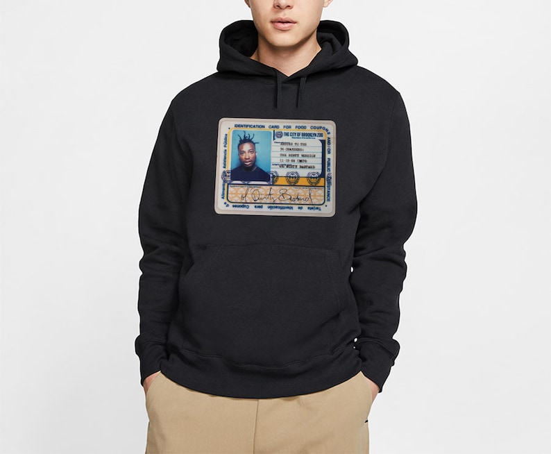 May include: Black hooded sweatshirt featuring a graphic of an ID card. The ID card has a photo of a person and text that reads "IDENTIFICATION CARD FOR FOOD COUPONS". The sweatshirt has a kangaroo pocket.