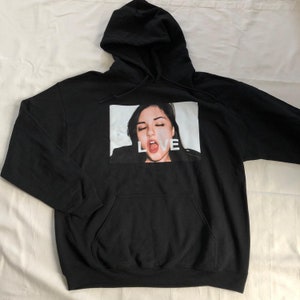 May include: Black hooded sweatshirt with a graphic print of a woman's face and the word "LOVE" printed below the image.