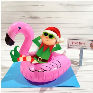 May include: A cartoon elf wearing sunglasses and a Santa hat relaxes on a pink inflatable flamingo in a pool. The elf is dressed in a green tunic and red and white striped socks. A sign reads "Pool Time" with the text "kicking back & relaxing today."