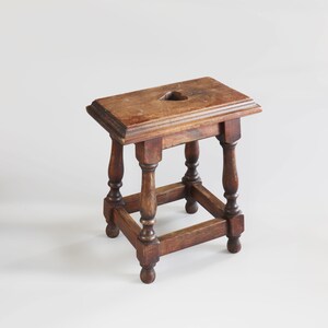 Uno sgabello tirolese primitivo in legno massello, realizzato