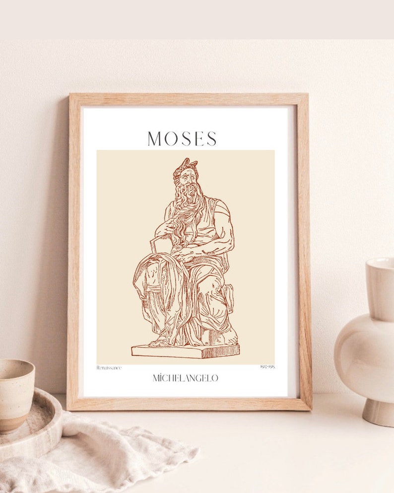 May include: A framed print of a line drawing of the Moses sculpture by Michelangelo. The sculpture is depicted in a seated pose with a beard and a crown. The print is on a beige background with the title "MOSES" and the artist's name "MICHELANGELO" in brown text.