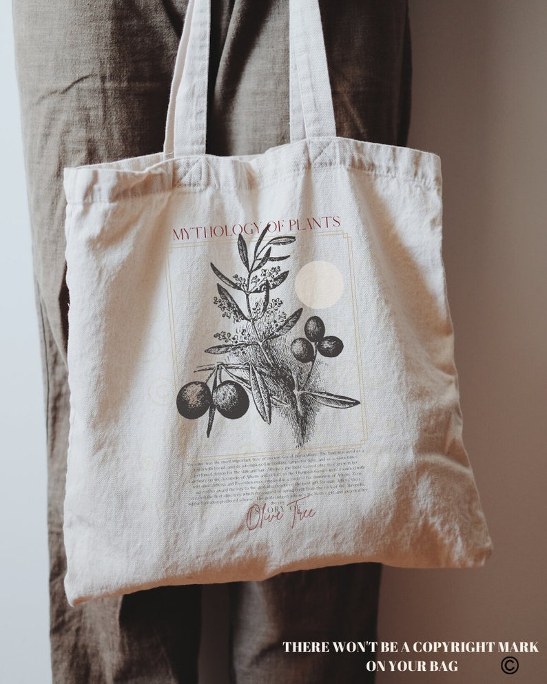 Pode incluir: Uma bolsa de tecido branca com ilustra&ccedil;&otilde;es em preto e branco de uma oliveira e azeitonas. O texto "MYTHOLOGY OF PLANTS" e "Olive Tree" est&aacute; impresso em vermelho na bolsa. O texto "THERE WON'T BE A COPYRIGHT MARK ON YOUR BAG" est&aacute; impresso na parte inferior da bolsa.