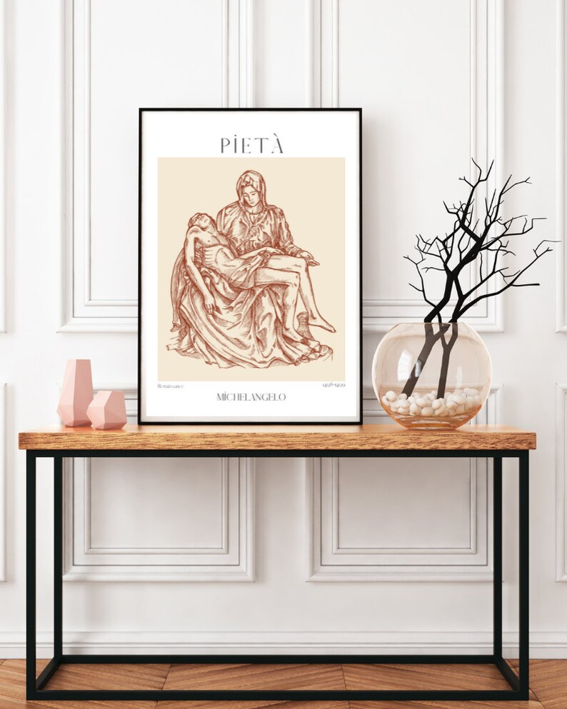 May include: A black framed print of a line drawing of Michelangelo's Pieta sculpture. The drawing is in brown on a cream background. The title "PIETA" and the artist's name "MICHELANGELO" are printed below the drawing.
