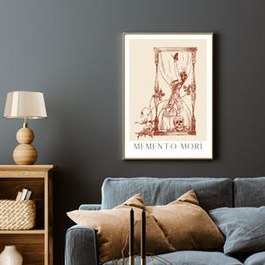 May include: A vintage-style print featuring a red hourglass, a skull, and a butterfly. The print has a cream background and the text "MEMENTO MORI" at the bottom.