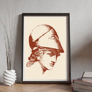 May include: A brown and white print of a woman's head wearing a helmet. The print is in a black frame.