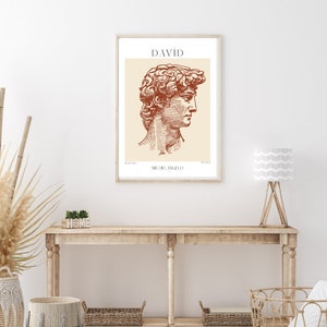 May include: A framed print of a line drawing of the David sculpture by Michelangelo. The drawing is in shades of brown and beige. The title "DAVID" and the artist's name "MICHELANGELO" are printed below the drawing.
