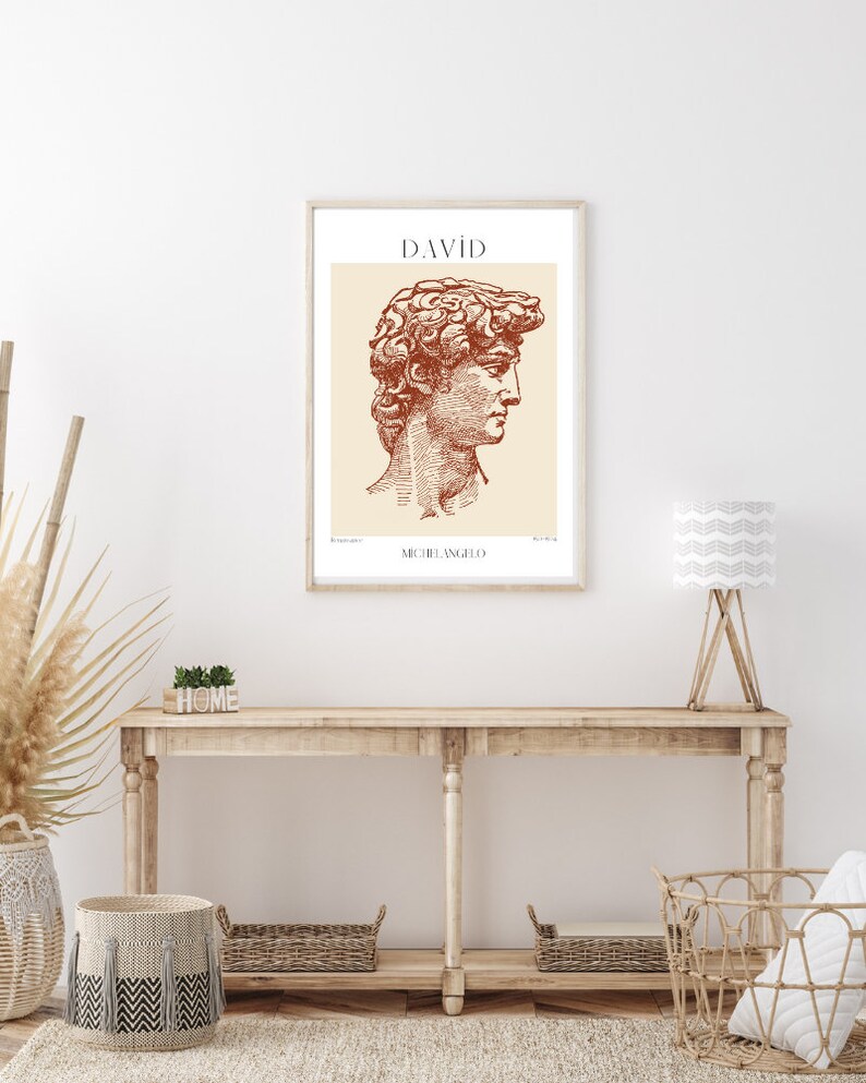 May include: A framed print of a line drawing of the David sculpture by Michelangelo. The drawing is in shades of brown and beige. The title "DAVID" and the artist's name "MICHELANGELO" are printed below the drawing.