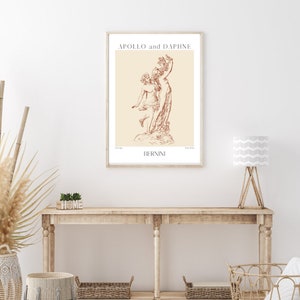 May include: A beige poster with a brown line drawing of a sculpture titled "Apollo and Daphne" by Bernini.