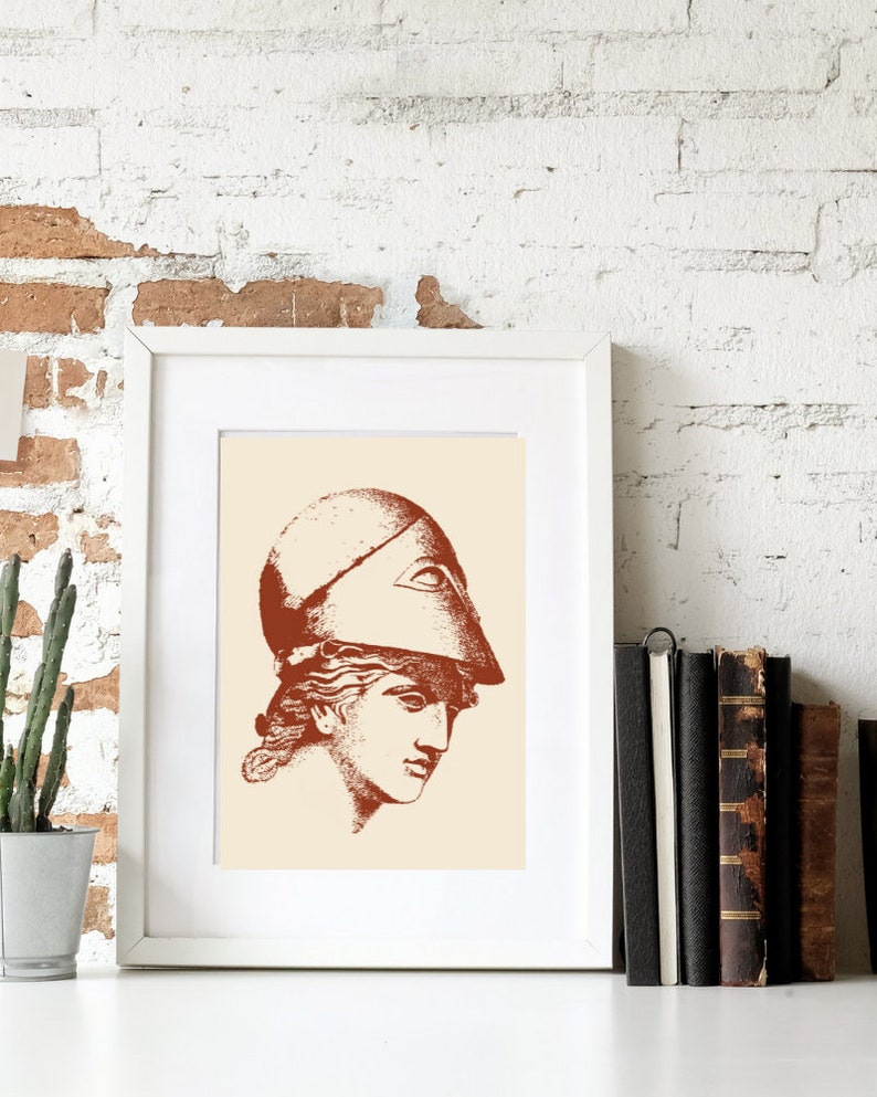 May include: A framed print of a line drawing of a woman's head wearing a helmet. The drawing is in shades of brown on a cream background.