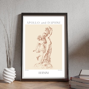 May include: A black framed print of a line drawing of the sculpture "Apollo and Daphne" by Gian Lorenzo Bernini. The print is on a cream background with the title and artist's name in brown text.