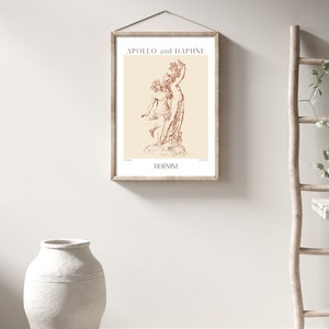 May include: A framed print of a line drawing of the sculpture "Apollo and Daphne" by Gian Lorenzo Bernini. The print is on a cream background with the title and artist's name in brown text.