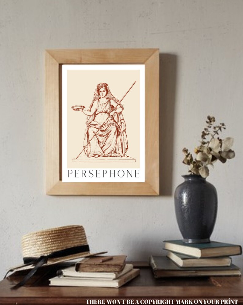 May include: A framed print of a line drawing of Persephone, a Greek goddess, in a seated pose. She is holding a bowl in her left hand and a staff in her right hand. The print is on a cream background with the word "PERSEPHONE" printed in brown below the image.