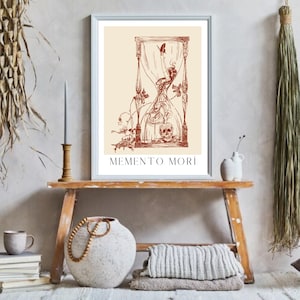 May include: A framed print featuring a brown hourglass illustration. The hourglass is filled with a skeletal figure and a butterfly. The text "MEMENTO MORI" is printed below the image.
