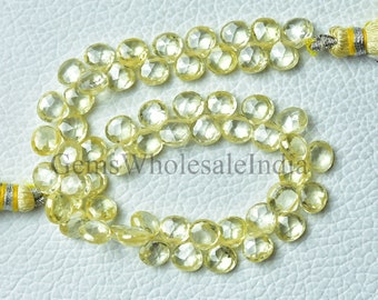May include: A strand of light yellow faceted gemstone beads with a tassel on each end. The beads are approximately 10mm in diameter.  Gems Wholesale India.