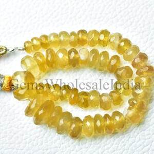 Könnte beinhalten: Eine Strähne gelber facettierter Edelsteinperlen. Die Perlen sind etwa 6 mm groß und haben eine glatte, polierte Oberfläche. Die Strähne ist etwa 45 cm lang und perfekt für die Herstellung von Schmuck.